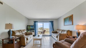 Ein geräumiges Wohnzimmer mit zwei Sofas, einem Couchtisch und einem Fernseher.