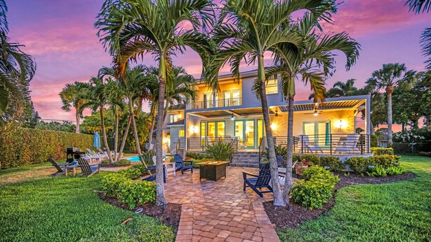 A modern two-story house with a patio area, outdoor seating, and a pool. - The Sun Dial | Waterfront Home on Siesta Key w/ Private Pool & Large Backyard, Close to Beach! (Siesta Key)