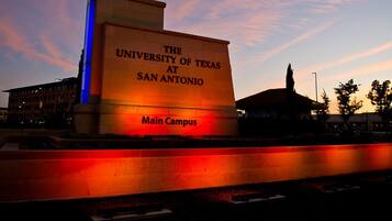 The University of Texas at San Antonio main campus sign illuminated at dusk.
