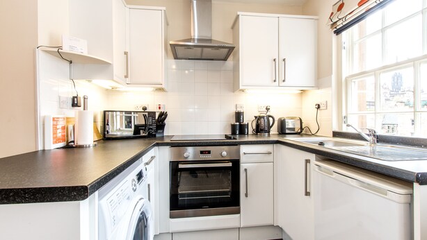 A modern kitchen with a washing machine, oven, and coffee maker. - Under Edinburgh Castle (Edinburgh)