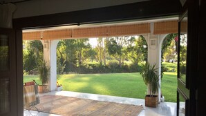 A spacious room with a large glass door leading to a well-maintained garden.