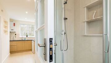 A modern bathroom with a glass shower enclosure, a sink, and a toilet.