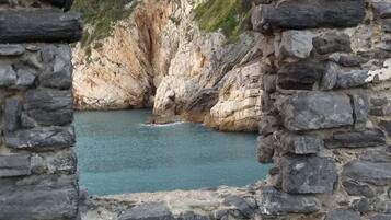 Un arco de piedra que da paso a un acantilado costero con un mar turquesa.