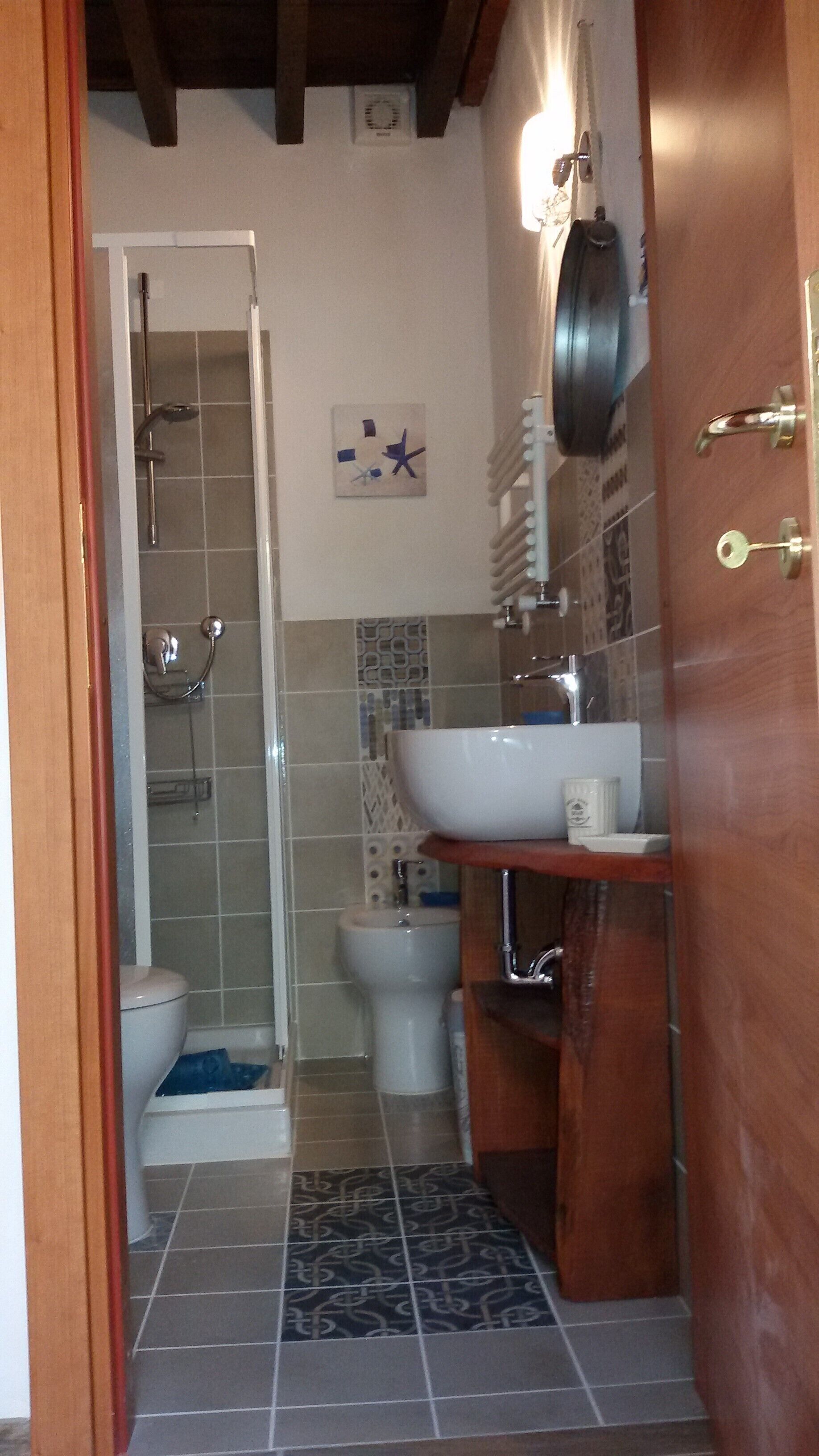 Ein kleines Badezimmer mit Dusche, Toilette und Waschbecken.