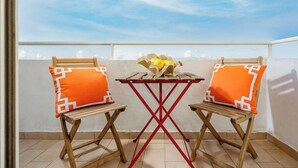 A balcony with two wooden chairs and a small table, each with orange cushions, and a basket of lemons on the table. - Comfortable 2-bed apartment, sleeps 6. Tastefully decorated and spacious. Perfect base to explore the Algarve — Lagos, Albufeira and beyond. Free street parking. Easy self check-in. Always on hand to help. (Portimão)