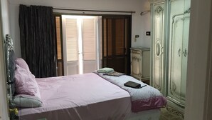 A bedroom with a bed, a wardrobe, and a window with blinds. - Apartment with a prefect sea view  (Stanly)