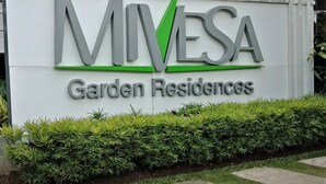 Een bord voor MIVESA Garden Residences met een modern ontwerp, met een opvallend logo en de naam van de residentie.