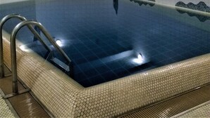 A swimming pool with a tiled interior, a metal ladder, and a tiled floor around the pool. - Lykkelig Ferie: bright apartment, south-facing balcony, beach 30 m, indoor pool, IR cabin, sauna (Kronsgaard)
