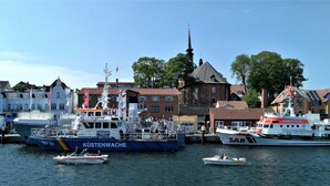 A harbor with boats, a church, and buildings. - Lykkelig Ferie: bright apartment, south-facing balcony, beach 30 m, indoor pool, IR cabin, sauna (Kronsgaard)