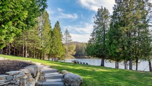 Un sentier de pierres qui mène à un lac bordé d’arbres.
