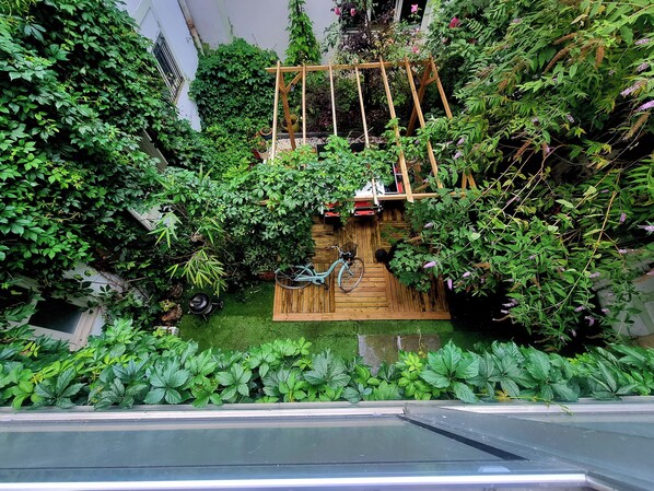 A lush garden with a wooden trellis, a bicycle, and a variety of plants.