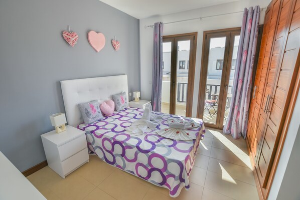 A bedroom with a bed, nightstands, a window with curtains, and a balcony. - Casa Zen Pool Sea & Sun Best accomodattion in a luxury urbanization and exclusiv (Puerto Calero Yaiza Las Palmas España)