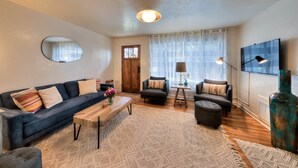 A living room with a sofa, armchairs, a coffee table, and a rug. - Desert Gardens #1 (Moab)