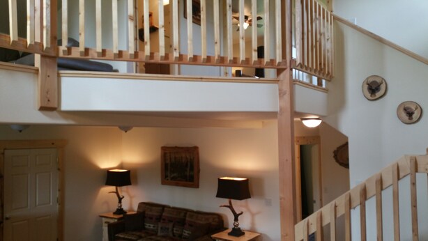 A multi-level wooden staircase with a loft bedroom above. There is a sofa and two lamps in the lower level. - Walk to The RIVER! Brand New 3 Bed/2 Bath. W/ FIRE PIT! (Sterling)