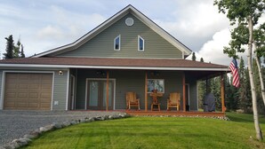 A two-story house with a covered porch, a garage, and a well-maintained lawn. - Walk to The RIVER! Brand New 3 Bed/2 Bath. W/ FIRE PIT! (Sterling)