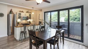 Una cocina moderna con una isla integrada, electrodomésticos de acero inoxidable y un comedor con mesa y sillas.
