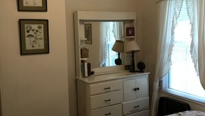 Un dormitorio con dos camas, un tocador, un espejo y cuadros en la pared.