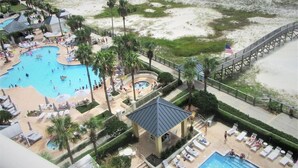 Ett semesterhotell med flera pooler, en strand och en brygga.