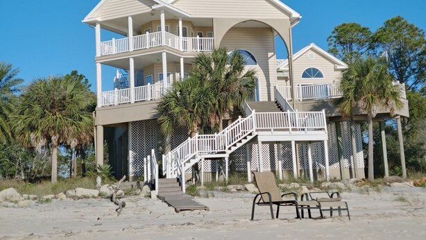 A two-story beach house with a balcony, a covered porch, and a staircase leading to the upper level. - Beachfront, kid friendly seas, seclusion, nature (Carrabelle)