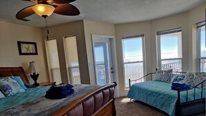 A bedroom with two beds, a ceiling fan, and a view of the ocean. - Beachfront, kid friendly seas, seclusion, nature (Carrabelle)
