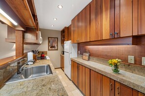 Enjoy cooking in this well-equipped kitchen with a stainless steel sink, oven, and refrigerator.