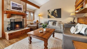 A cozy living room with a fireplace, a sofa, a coffee table, and a bookshelf. - RMR: Thistle 921 Condo in The Aspens/Wilson,WY (Wilson)