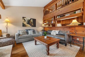 Cozy living room with a bookshelf, comfortable sofa, and wooden coffee table, perfect for relaxation and socializing.