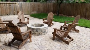 A patio with four Adirondack chairs arranged around a stone fire pit. - HISTORIC DISTRICT ~ Free Parking! (Saint Augustine)