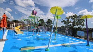 A water park with slides, water jets, and umbrellas.