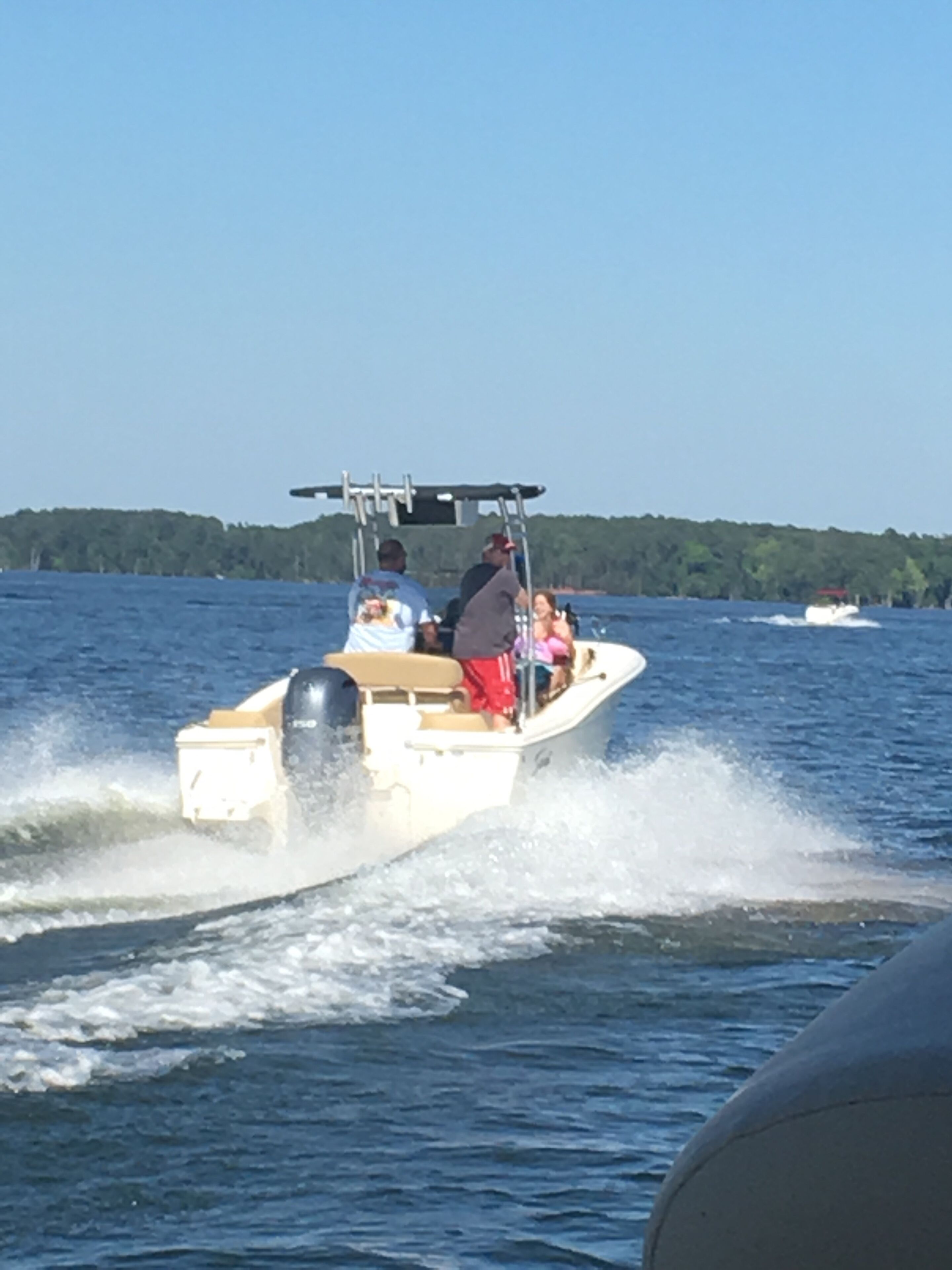 A speedboat on a lake with passengers.