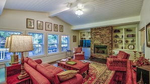 A cozy living room with red furniture, a fireplace, and a brick wall. - Location, Location, Location. (Highlands)