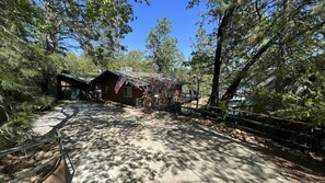 Escape to a secluded cabin surrounded by a lush forest, featuring a cozy porch and a serene atmosphere.