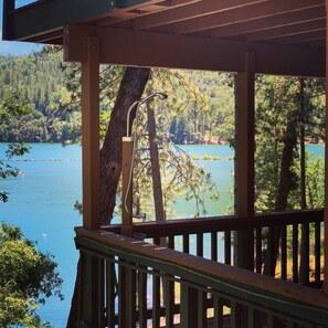Enjoy a serene lakeside view from this deck surrounded by dense forest.