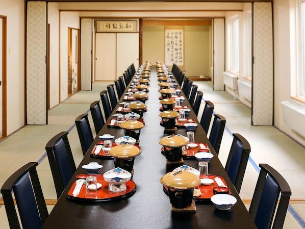 A long dining table with multiple chairs, arranged in a conference style.