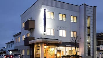 A multi-story hotel with a modern facade, large windows, and a well-lit entrance.