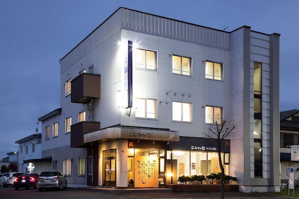 Un hotel de varios pisos con fachada moderna, ventanas amplias y una entrada bien iluminada.