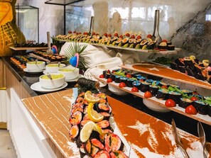 A buffet with various dishes, including sushi and seafood. - grand uysal (alanya tosmur)