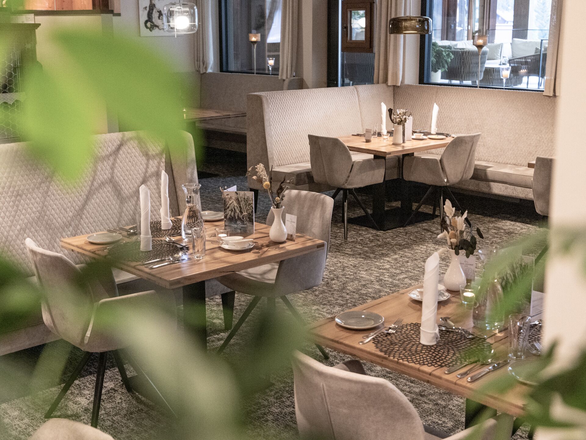 A dining area with tables set for two, featuring a mix of modern and classic decor.