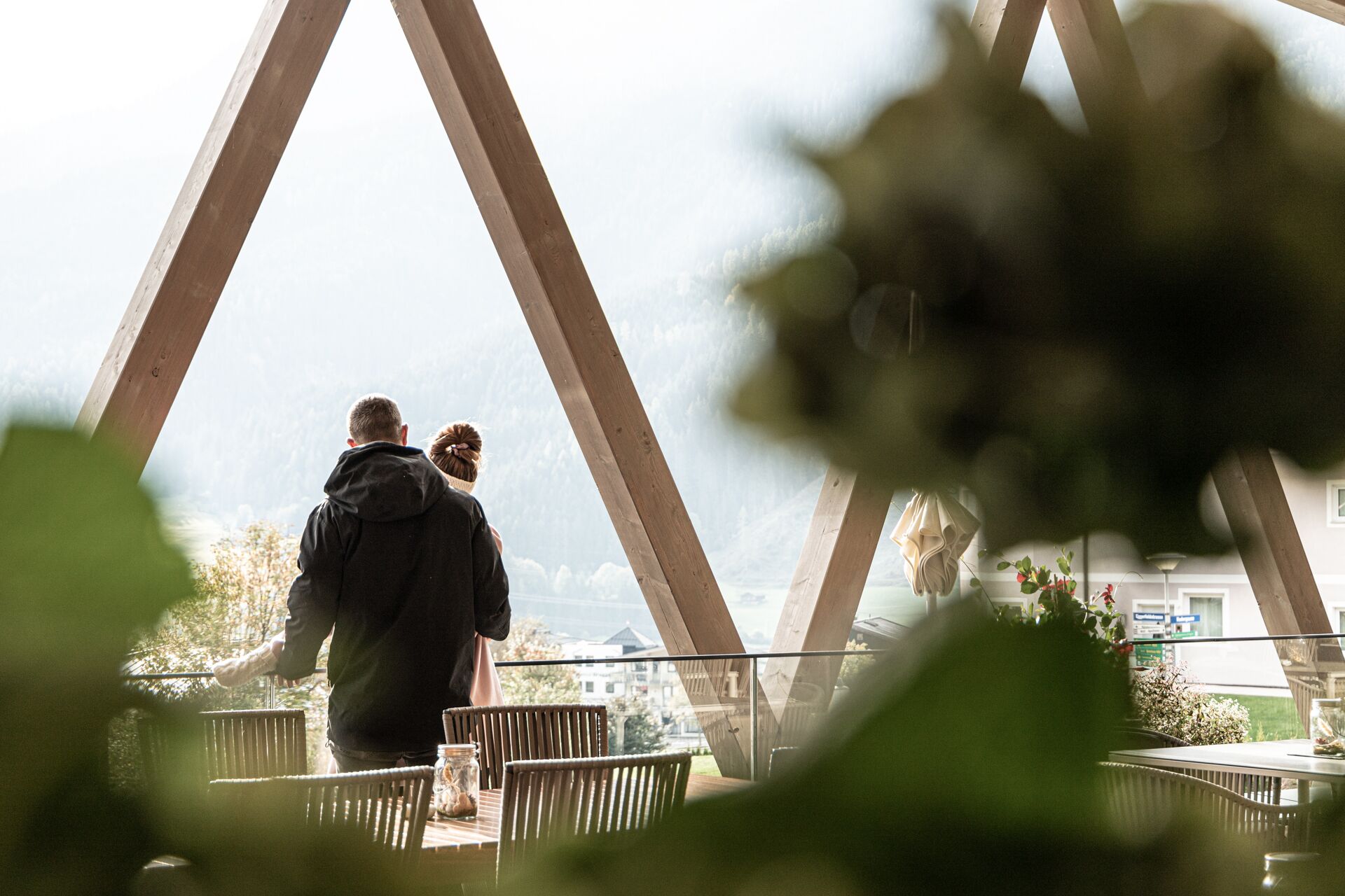 Ein Paar steht auf einem Balkon mit Blick auf eine Brücke und Gebäude.