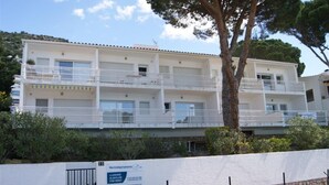 Un immeuble à plusieurs étages, doté de balcons, d’une façade blanche et d’une enseigne indiquant qu’il est à louer.