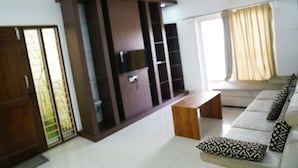Un salon moderne avec un canapé, un meuble en bois et un ventilateur de plafond.