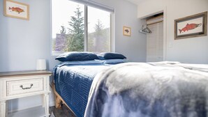 Une chambre à coucher avec un lit, une table de chevet, une fenêtre et un placard.