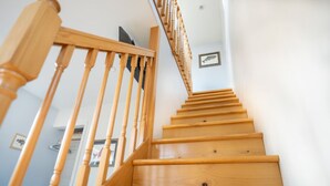 Un escalier en bois avec une rampe et un tableau accroché au mur.