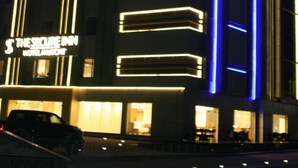 Een hotel met een modern design, met verlichte neonlichten in blauw en geel.