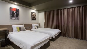 A hotel room with two beds, a wooden headboard, a nightstand, and a large window with curtains. - Toptel Thaphra (Bangkok)