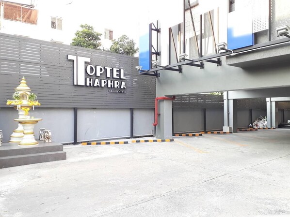 L’extérieur de l’hôtel Topel Haphra se distingue par sa façade moderne, son grand portail d’entrée et sa fontaine décorative.