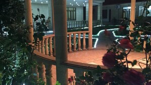 Un espace extérieur abrité, doté d’une colonnade circulaire, d’un sol carrelé et d’une balustrade.