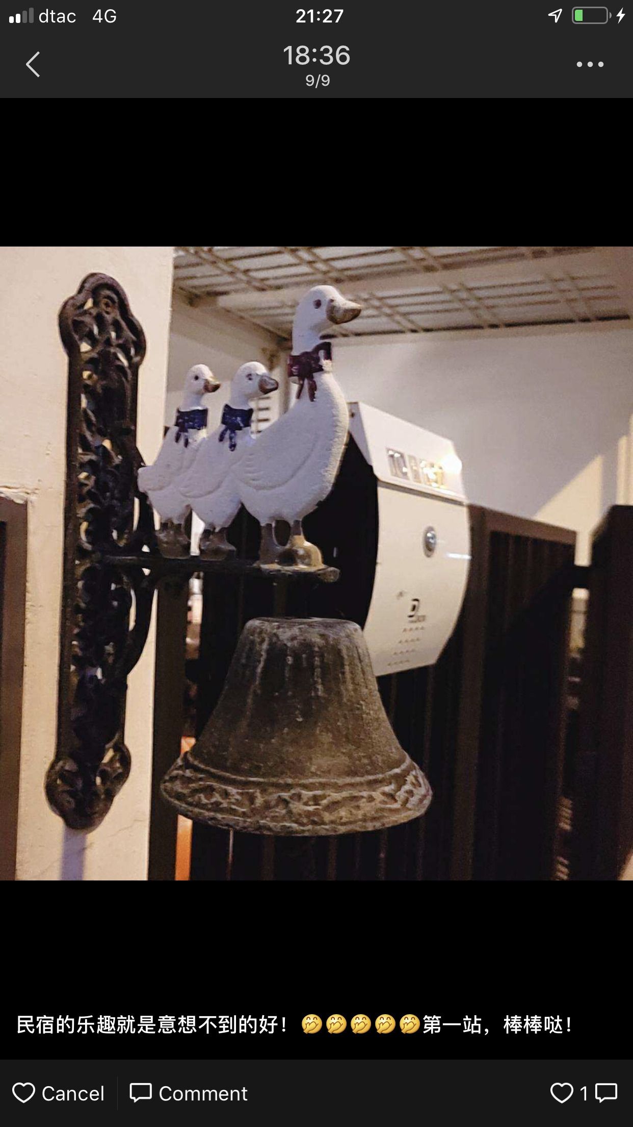 A decorative bell with two white birds on top, mounted on a wall.