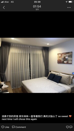 Une chambre d’hôtel avec un lit, des rideaux et un tableau au mur.