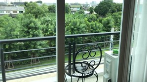 Een balkon met een metalen stoel en een witte radiator.